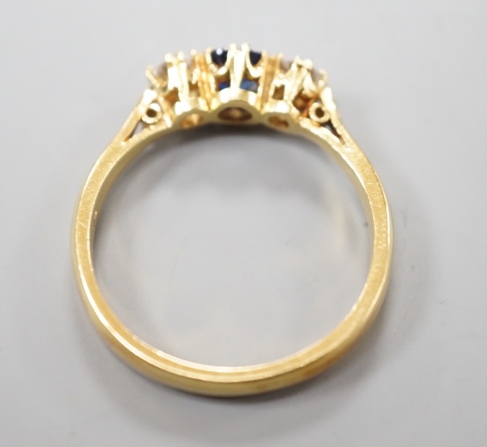 A modern 18ct gold, sapphire and diamond set three stone ring, size S, gross weight 4.4 grams